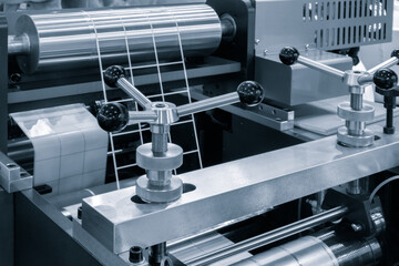 Poster - Automatic polyethylene plastic bag production machine with lighting effect. Close-up of the roller of the plastic bag production machine in the light blue scene. product packaging concept