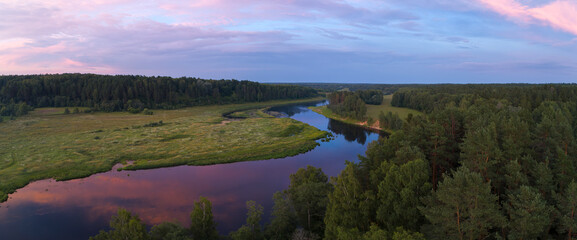 Aufkleber - A river with a forest on either side. The water is calm and the sky is a mix of blue and purple
