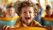 © stockpro - A joyful child with curly hair, laughing while enjoying a fun ride at an amusement park, surrounded by friends.