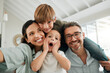 © peopleimages.com - Selfie, smile and surprise with family on sofa in living room of home together for bonding, fun or game. Profile picture, social media or wow with mother, father and children in apartment for love