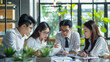© Mahemud - Asian business team meeting in a modern office, focusing on design planning and ideas.