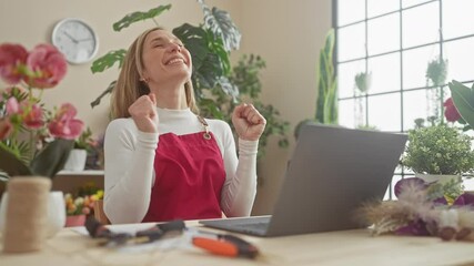 Poster - Triumph-filled celebrations at the flower shop, a young, joyful blonde florist, sitting at table, exudes happiness through her winning smile and victorious expression. confidence and joy abound!