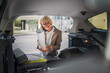 © Miljan Živković - mature blonde woman travel take stuff belongings from the back of car