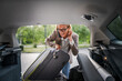 © Miljan Živković - mature blonde woman travel take stuff belongings from the back of car