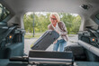 © Miljan Živković - mature blonde woman travel take stuff belongings from the back of car