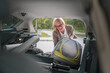 © Miljan Živković - mature blonde woman travel take stuff belongings from the back of car