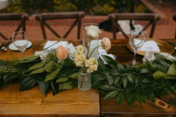 Wall Mural - Elegant table setting with floral centerpiece and greenery at an outdoor event