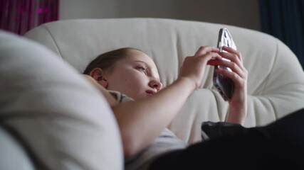 Poster - caucasian teenager uses her mobile phone to surf internet and chat with friends in social network. y