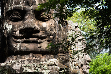 Wall Mural - Closeup of huge head sculpture at the historic temple complex of Angkor Wat in Siem Reap, Cambodia