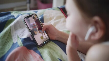 Poster - close up shot of young girl lying on bed at home, surfing internet and scrolling social networks usi