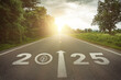 © MangKangMangMee - New year 2025 straightforward for environmental sustainability concept. Text 2025, save the world, leaf icon on the road in the middle of asphalt road at sunset. Ecological balance, sustainability.