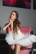 © Moiseii Production - A ballerina in a white tutu and pointe shoes sits on a chair