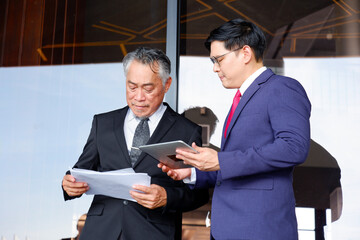 Wall Mural - Businessman holding tablet and documents discussing work and business plans.