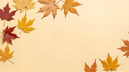 Top view of dry maple autumn leaves on pastel yellow background with ample copy space for text