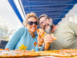 © simona - Cheerful tourist couple posing for a picture eating pizza margherita together having fun. Dating and relationship man and woman at pizzeria. Italian food. Portrait of male and female in relationship