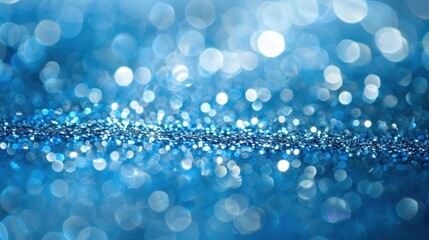 Sparkling blue glitter and bokeh lights create a dreamy and festive abstract background perfect for celebrations.