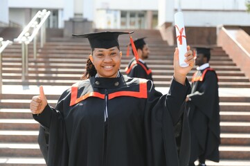 Wall Mural - pretty african female college graduate at graduation with classmates