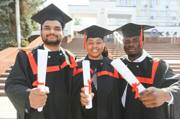 Wall Mural - Diverse international students with diplomas at university campus