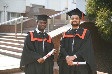 Wall Mural - Two friends are university graduates. Indian and African graduates