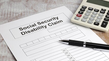 Wall Mural - Disability claim form social security desk with calculator and pen.