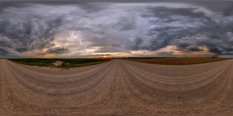 Wall Mural - hdri 360 panorama on gravel road among fields in nasty evening before sunset with dark clouds in equ