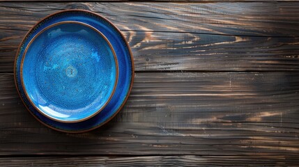 Canvas Print - Blue plate on wooden surface with copy space top view