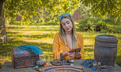 Wall Mural - Gypsy soul... Boho woman with a magic stuff, candles, others at field, lifestyle, predicting, ideas for costume on Halloween