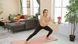 © Krakenimages.com - A young woman practices yoga in a modern living room, focusing on health and wellness.