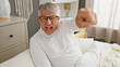 © Krakenimages.com - Middle-aged man in glasses yelling, expressing frustration while sitting in bed in a bedroom setting.