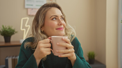 Poster - Caucasian woman with blonde hair enjoying coffee at home, looking away in a living room.