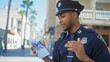 © Krakenimages.com - African american police officer reviews a missing person flyer on a sunny city street.