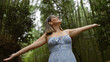 © Krakenimages.com - Joyful hispanic woman embraces freedom in kyoto's bamboo forest, smiling, posing with open arms, looking around. beautiful, confident, carefree latin adult in glasses enjoying japan's green beauty.