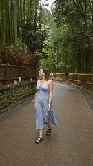 Poster - Beautiful hispanic woman with glasses, smiling confidently as she stands amongst kyoto's lush bamboo forest, looking around, full of joy and amazement.