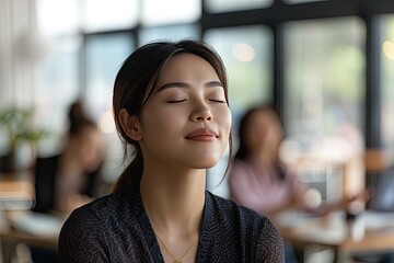 Canvas Print - A woman is sitting in a restaurant with her head down and a smile on her face. She is enjoying her meal and the atmosphere of the restaurant