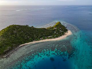 Wall Mural - aerial view of tropical islands in fiji at sunset. calm, shallow turquoise waters and coral reef sur