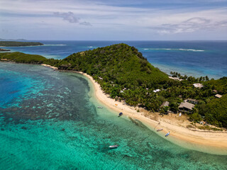 Wall Mural - aerial view of tropical island beach with shallow turquoise water and corals reefs seen from above. 