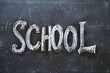 © serdjo13 - A chalkboard with the word 'school' written on it. The chalkboard is black and has a chalk outline of the word school