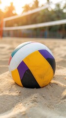 Wall Mural - A volleyball sits in the sand on a beach, with a volleyball net in the background and the ocean in the distance.