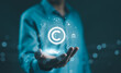 © Supatman - Digital copyright, patent concept. Businessman hold digital icons representing copyright, intellectual property, patents, legal protection, and safeguarding digital and intellectual assets. trademark,