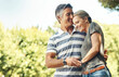 © ArcursPI/peopleimages.com - Happy, hug and couple in park walking for bonding, relationship and relax in morning outdoors. Nature, marriage and mature man and woman laughing for romance, affection and love on weekend together