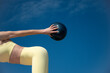 © Rob Wilkinson - close up of a sporty woman holding a small pilates exercise ball outdoors. Wearing yellow sports clothing