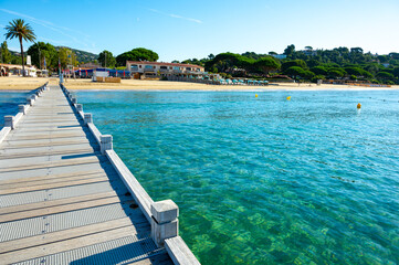 Morning view on crystal clear blue water of Plage du Debarquement white sandy beach near Cavalaire-sur-Mer and La Croix-Valmer, summer vacation on French Riviera, Var, France