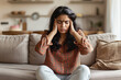 © ArtCraft - Distressed young woman at home. Ideal image for depicting migraine, stress, or frustration. Perfect for health, wellness, and mental healthrelated articles and marketing