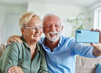 Wall Mural - senior woman man couple elderly love elderly selfie camera mobile phone smartphone photo picture portrait male old together active vitality cell phone hug