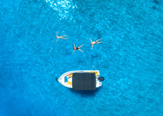 Wall Mural - Aerial view of alone small motorboat and swimming people in the sea in summer sunny day. Beautiful Oludeniz, Turkey. Top drone view of bay, boat, family, transparent blue water, sand, Travel. Vacation