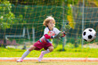 © famveldman - Child playing football. Kids play soccer.
