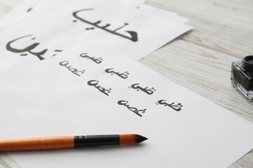 Wall Mural - Calligraphy. Papers with word Branch in Arabian language and brush on white table, closeup