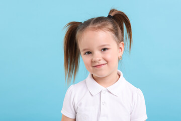 Wall Mural - Portrait of cute little girl on light blue background