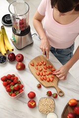 Sticker - Woman making delicious smoothie with blender at white marble table in kitchen, above view