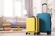 © New Africa - Two color suitcases on floor at home, space for text